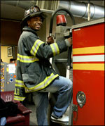 Tory Jackson climbs onto an FDNY firetruck